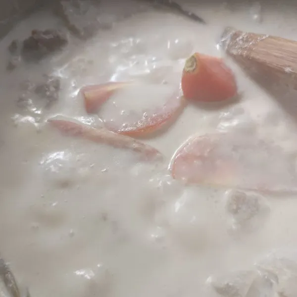 Masukkan susu, beri garam dan gula. Koreksi rasa. Masak hingga daging empuk dan bumbu meresap. Masukkan potongan tomat sesaat sebelum matang.