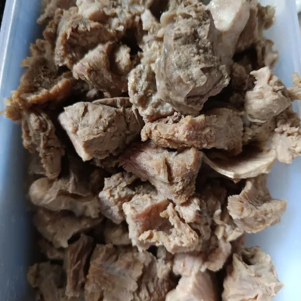 Rebus daging hingga cukup empuk. Buang air darahnya. Tiriskan daging, potong-potong.