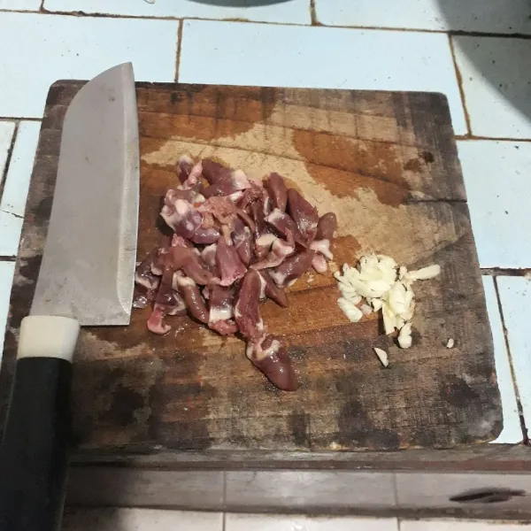 Cincang bawang putih dan potong menjadi 2 jantung ayam.