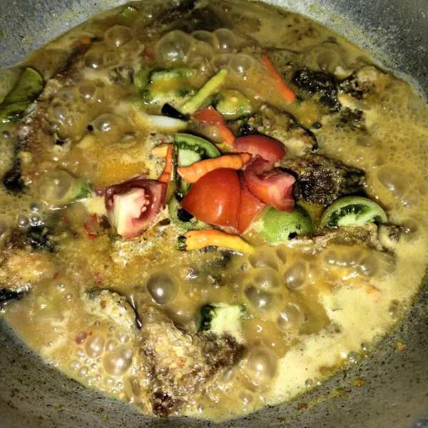 Kemudian masukkan cabai rawit dan irisan tomat hijau dan merah aduk sampai rata.