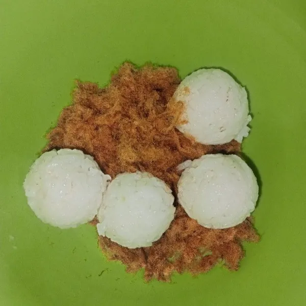 Gulingkan setengah bagian nasi ke dalam abon sapi.