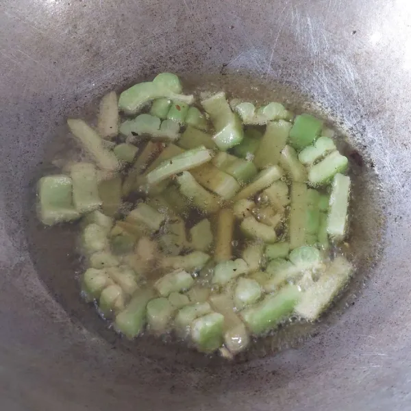 Panaskan minyak goreng, lalu goreng pare hingga matang.