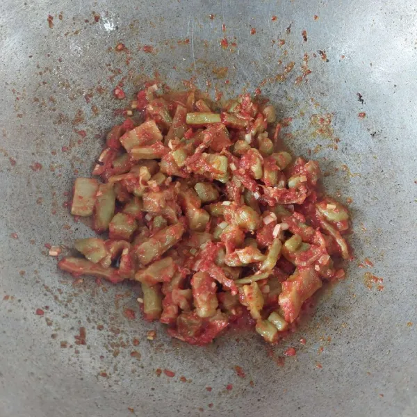 Tambahkan pare dan ikan teri, aduk hingga terbalur rata.