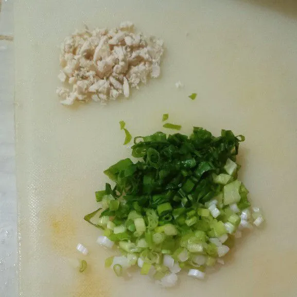 Potong kecil-kecil daun bawang dan ayam rebus.