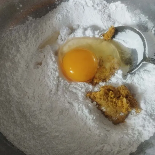 Kemudian masukkan bumbu ke dalam campuran tepung. Tambahkan telur, aduk rata