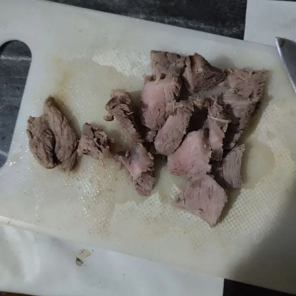 Iris daging sapi yang sudah direbus. Tekan sedikit dengan ulekan.