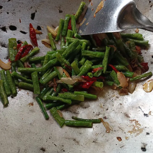 Masukkan kacang panjang, aduk rata. Tambahkan saus tiram, gula, garam dan merica. Aduk rata. Masak hingga kacang panjang cukup matang.