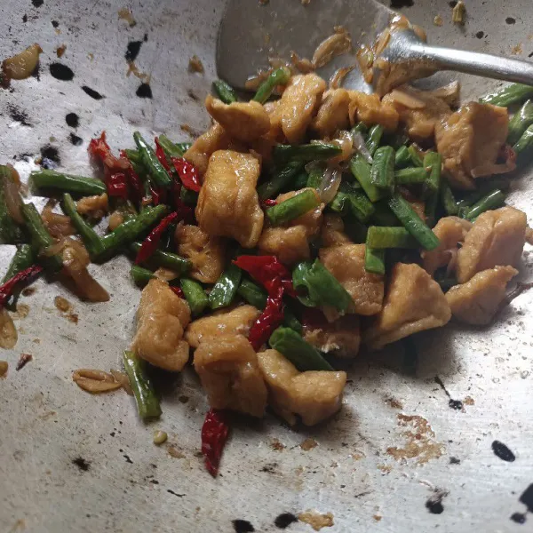 Masukkan tahu, aduk rata. Masak hingga kacang panjang matang dan bumbu meresap. Angkat dan sajikan.