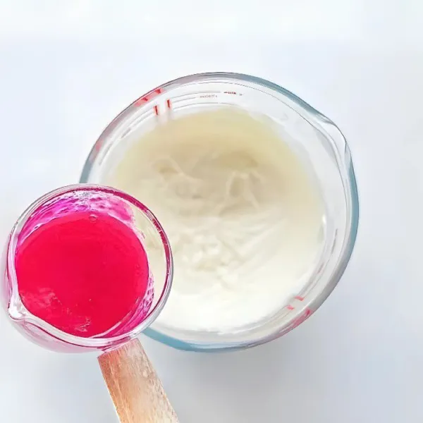 Tambahkan 80 gr puree buah naga ke dalam campuran dan aduk hingga rata