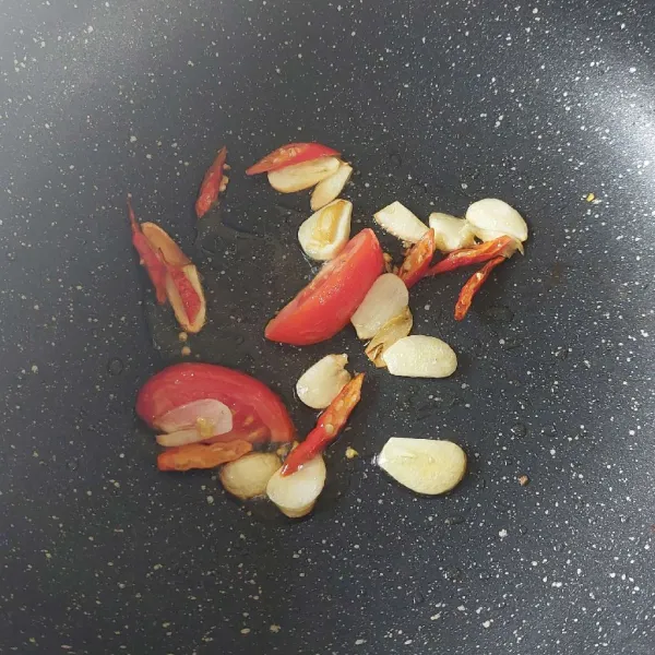 Tumis bawang putih, cabe dan tomat sampai layu.