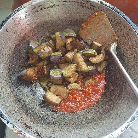 Masukkan terong yang sudah digoreng. Lalu tumis dan tambahkan air sedikit saja.
