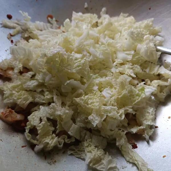 Masukkan potongan sawi bagian tengah daun lebih dulu. Masak beberapa saat, baru masukkan potongan daun sawi. Aduk rata.