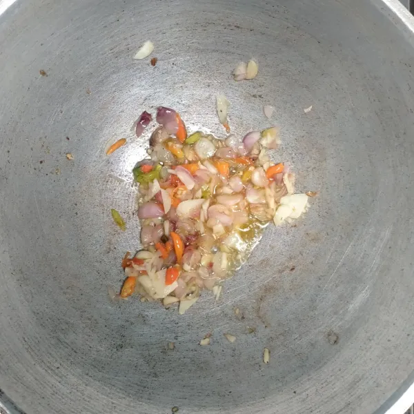 Panaskan minyak tumis. Kemudian bawang merah, bawang putih, dan cabe rawit hingga harum.