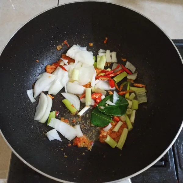 Masukkan irisan bawang bombay, daun bawang, cabe merah besar dan daun jeruk