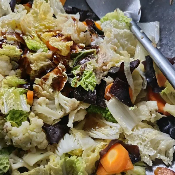Masukkan saus tiram, gula, garam dan merica bubuk. Aduk rata. Koreksi rasa. Masak hingga sayur matang dan bumbu meresap, koreksi rasa.