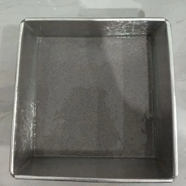 Siapkan loyang yang sudah dioles tipis minyak sayur. Lalu tuang satu bagian adonan ke dalam loyang.