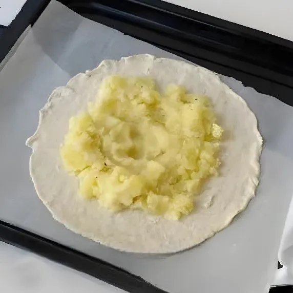 Ambil satu lembar kulit pastry 200 gr, letakkan di atas loyang yang sudah dialasi kertas roti. Oleskan lapisan 300 gr kentang halus di atas kulit pastry secara merata.