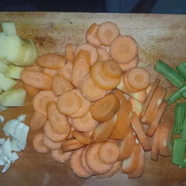 Potong dadu kentang dan potong juga buncis. Iris tipis wortel serta tomat, daun bawang, dan seledri.