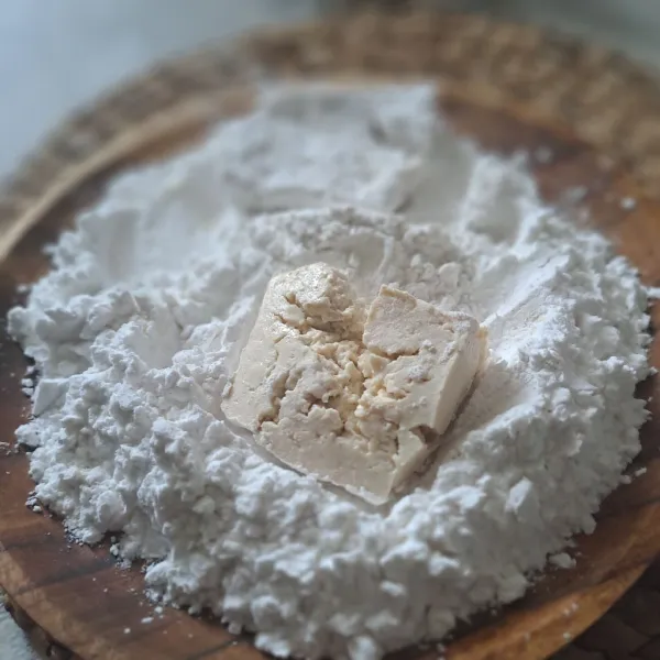 Masukkan tahu kemudian tekan-tekan sampai tahu terbalut dengan tepung tapioka.