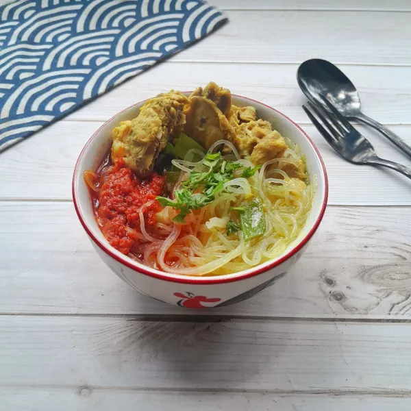 Tata bihun di dalam mangkok lalu siram dengan kuah soto beri toping tulangan ayam, daun seledri dan cabe goreng.