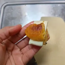 Ambil satu potong pisang, kemudian potong bagian tengah pisang tidak putus, sisipkan keju slice.