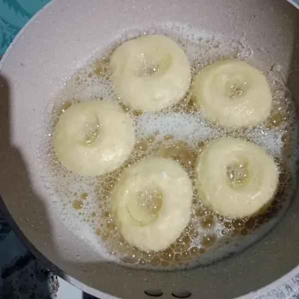 Goreng donat menggunakan api sedang cenderung kecil. Balik donat sekali saja agar tidak menyerap minyak. Angkat tiriskan