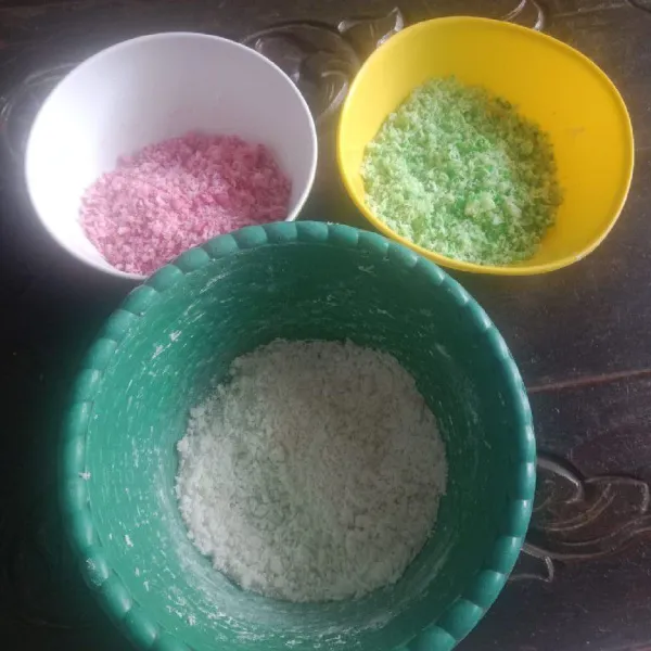 Bagi campuran tepung ketan yang sudah diberi parutan kelapa menjadi tiga bagian, kemudian campurkan masing-masing pewarna makanan aduk merata