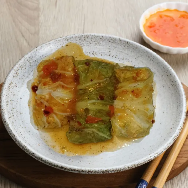 Sajikan sawi gulung siram dengan saus.