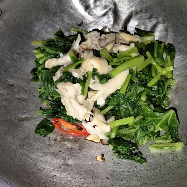 Kemudian setelah harum masukkan sayur sawi dan jamur aduk sampai rata.
