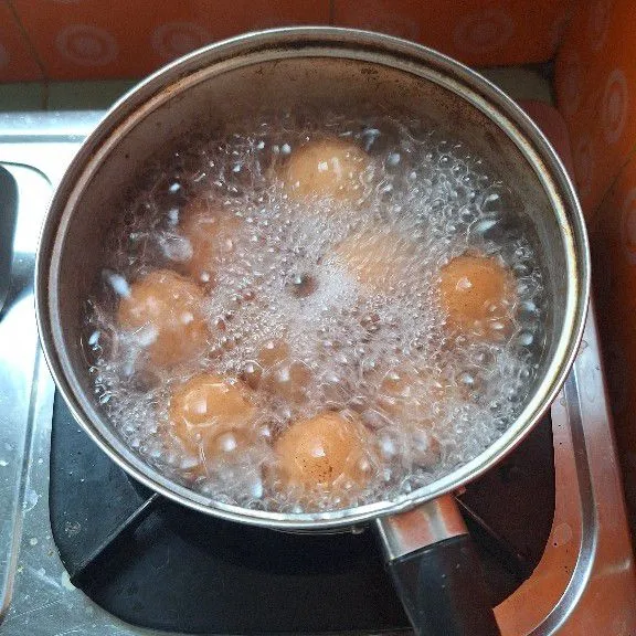 Rebus telur hingga matang, lalu rendam air dingin supaya mudah dikupas kulitnya.