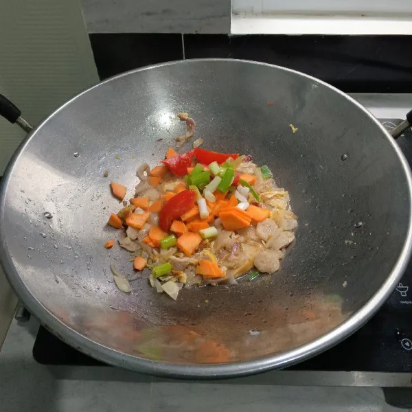 Masukkan irisan tomat, daun bawang dan wortel. Aduk rata.