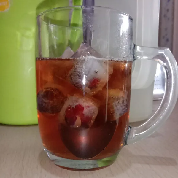 Masukkan es batu buah ke dalam gelas saji.