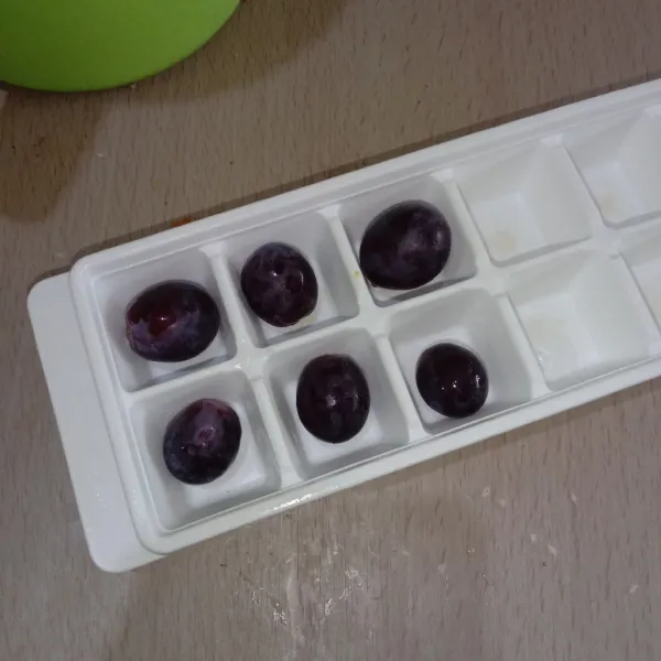 Masukkan buah anggur ke dalam cetakan es batu.