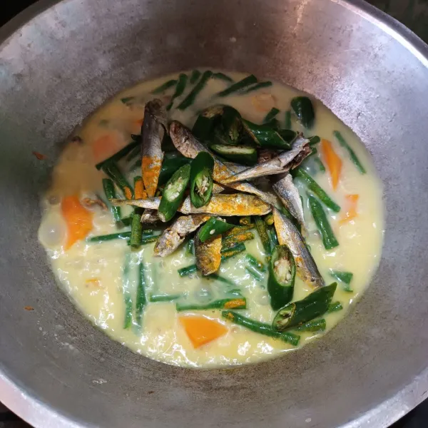 Kemudian masukan kacang panjang, ikan asih, cabe iji besar, dan kunyit bubuk. Aduk rata.
