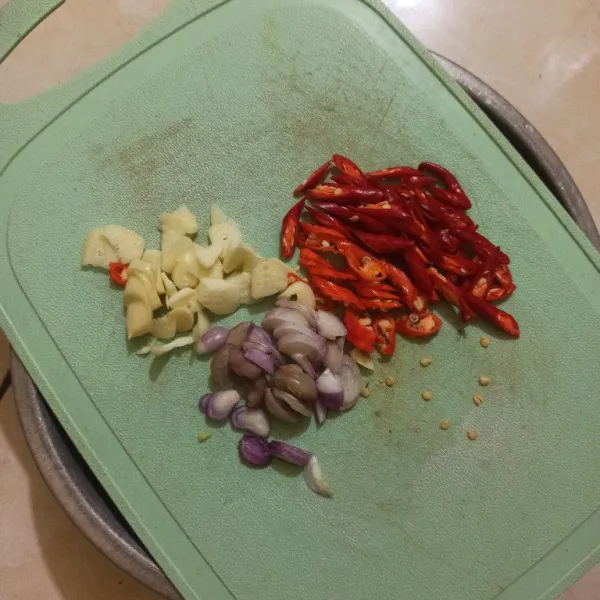 Iris tipis bawang putih, bawang merah, cabe rawit dan cabe merah besar.