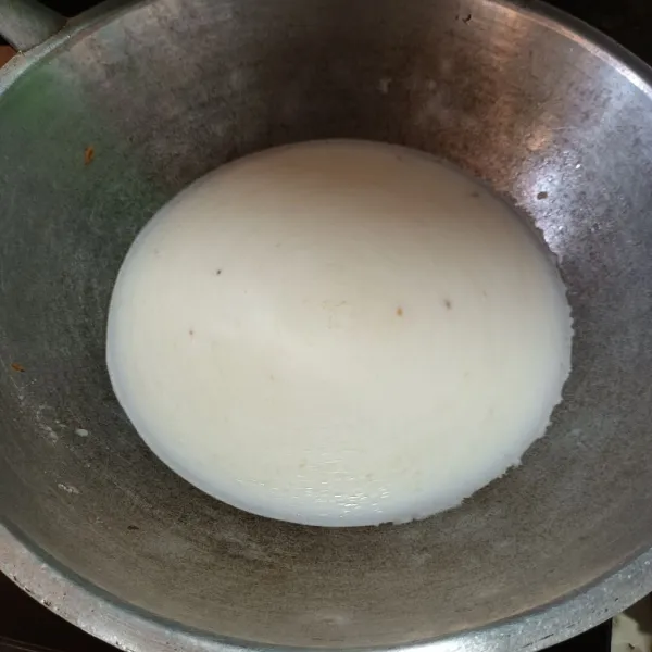 Tumis bawang merah dan bawang putih sampai harum. Lalu masukan air dan santan bubuk. Aduk rata.
