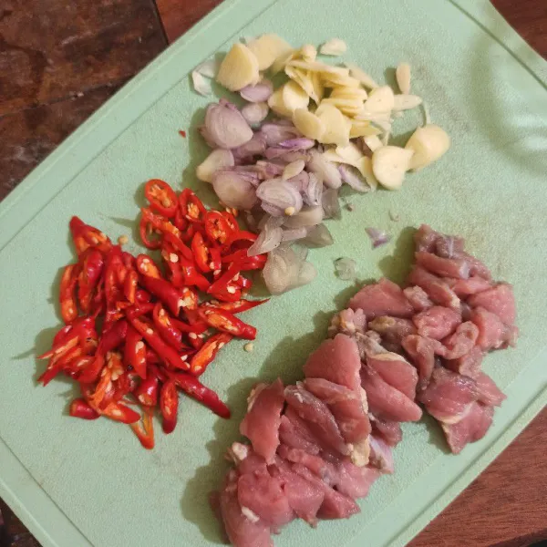 Iris tipis bawang putih, bawang merah, cabe merah besar, cabe rawit dan iris tetelan daging sapi.