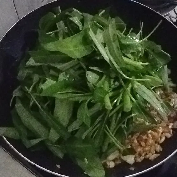 Step terakhir, masukkan kangkung yang sudah dicuci bersih. Kemudian, aduk sedikit hingga menyusut. Lalu, tambahkan garam dan bumbu penyedap. Setelah itu, aduk lagi sebentar dan matikan kompor. Cah kangkung siap disajikan!