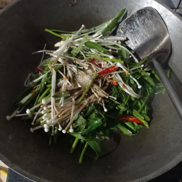 Masukan kangkung, jamur enoki, cabe, tomat, saus tiram, kecap manis, garam, gula, dan kaldu bubuk.