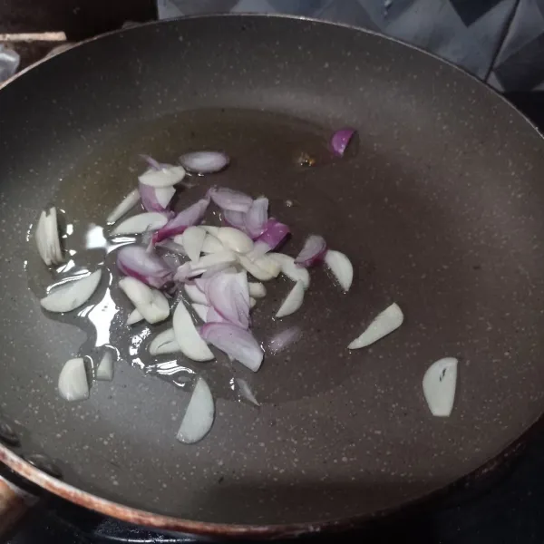 Tumis irisan bawang merah dan bawang putih sampai harum.
