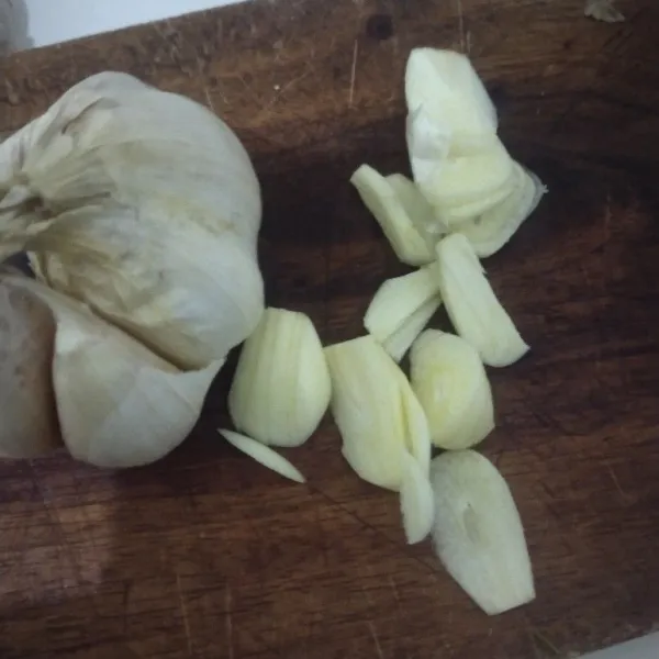 Potong dua siung bawang putih.