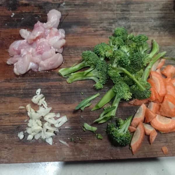 Iris brokoli, wortel, dan ayam. Lalu, cincang bawang putih.