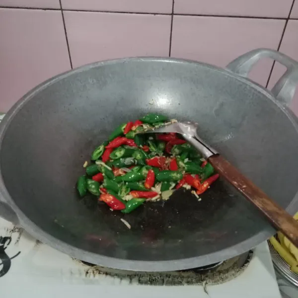 Masukkan cabe hijau dan cabe merah, tumis hingga layu.