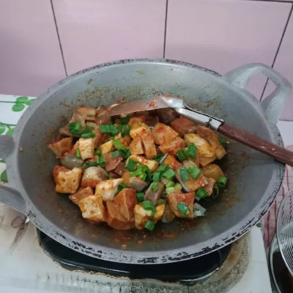 Masukkan terong, tahu, bakso, saos sambal, garam, penyedap, gula, dan lada bubuk. Aduk rata dan masak sampai bumbu meresap. Terakhir, masukkan irisan daun bawang. Hidangan siap disajikan!