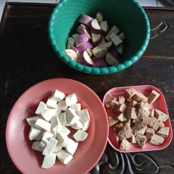 Cuci bersih terong, kemudian potong-potong. Potong juga bakso. Kemudian, cuci bersih tahu dan potong bentuk dadu.