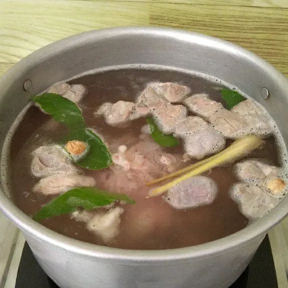 Rebus air hingga mendidih. Masukkan bumbu halus, daun jeruk, sereh, kapulaga, cengkeh, dan daging sapi iris.