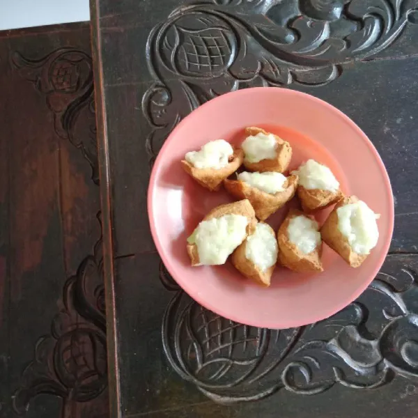 Siapkan tahu. Keluarkan isinya dan campurkan ke adonan tepung. Kemudian isi kembali tahu dengan adonan tepung. Sisihkan.