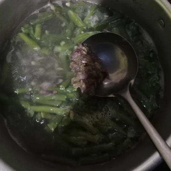 Masukkan bumbu ke dalam kacang panjang yang direbus.