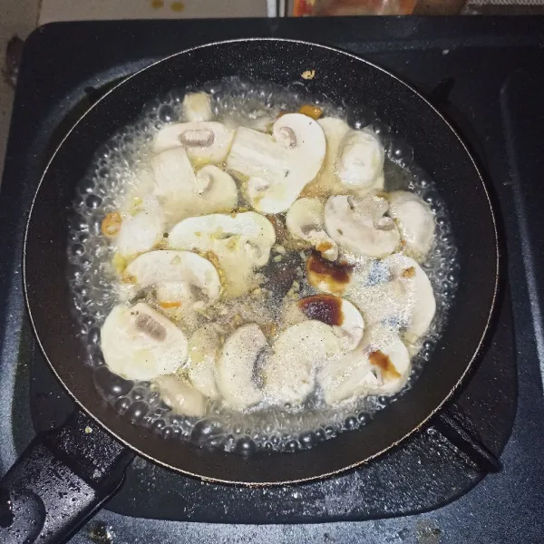 Masukkan jamur, beri seasoning, dan tambahkan air serta larutan tapioka.