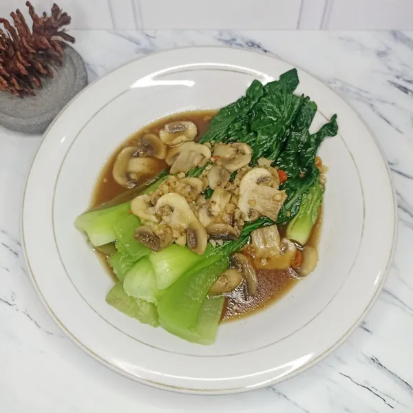 Tata sawi pada piring dan siram dengan saus jamur.